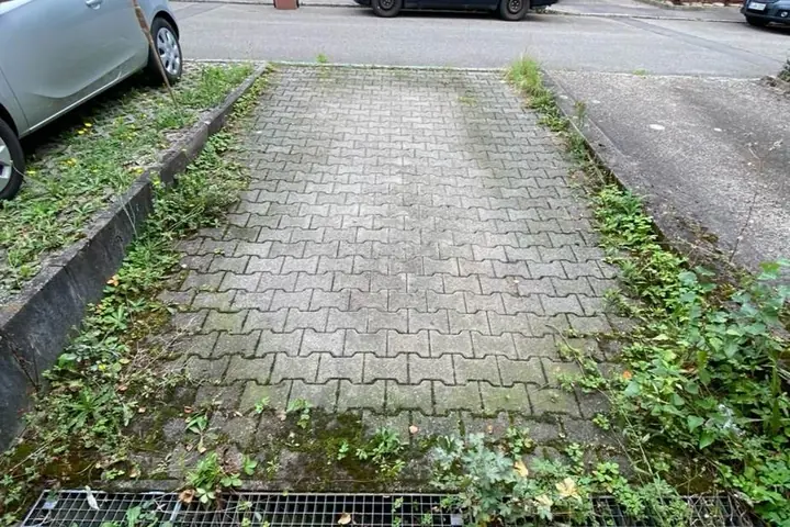 Parkplatzfläche vor der Reinigung, stark verschmutzt
